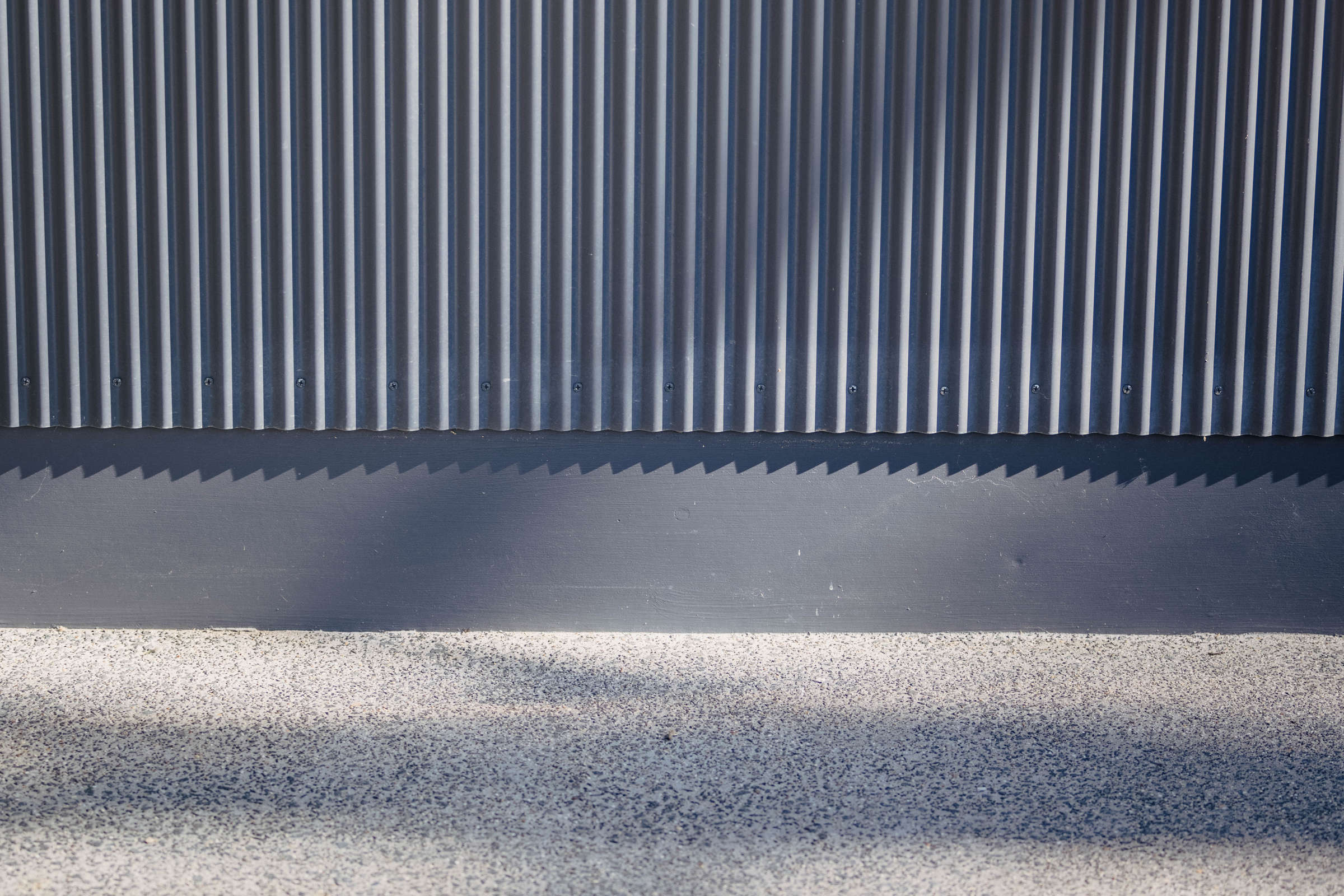 Wall cladding in custom mini orb and a concrete path with exposed aggregate. Photo: Jordan Davis.