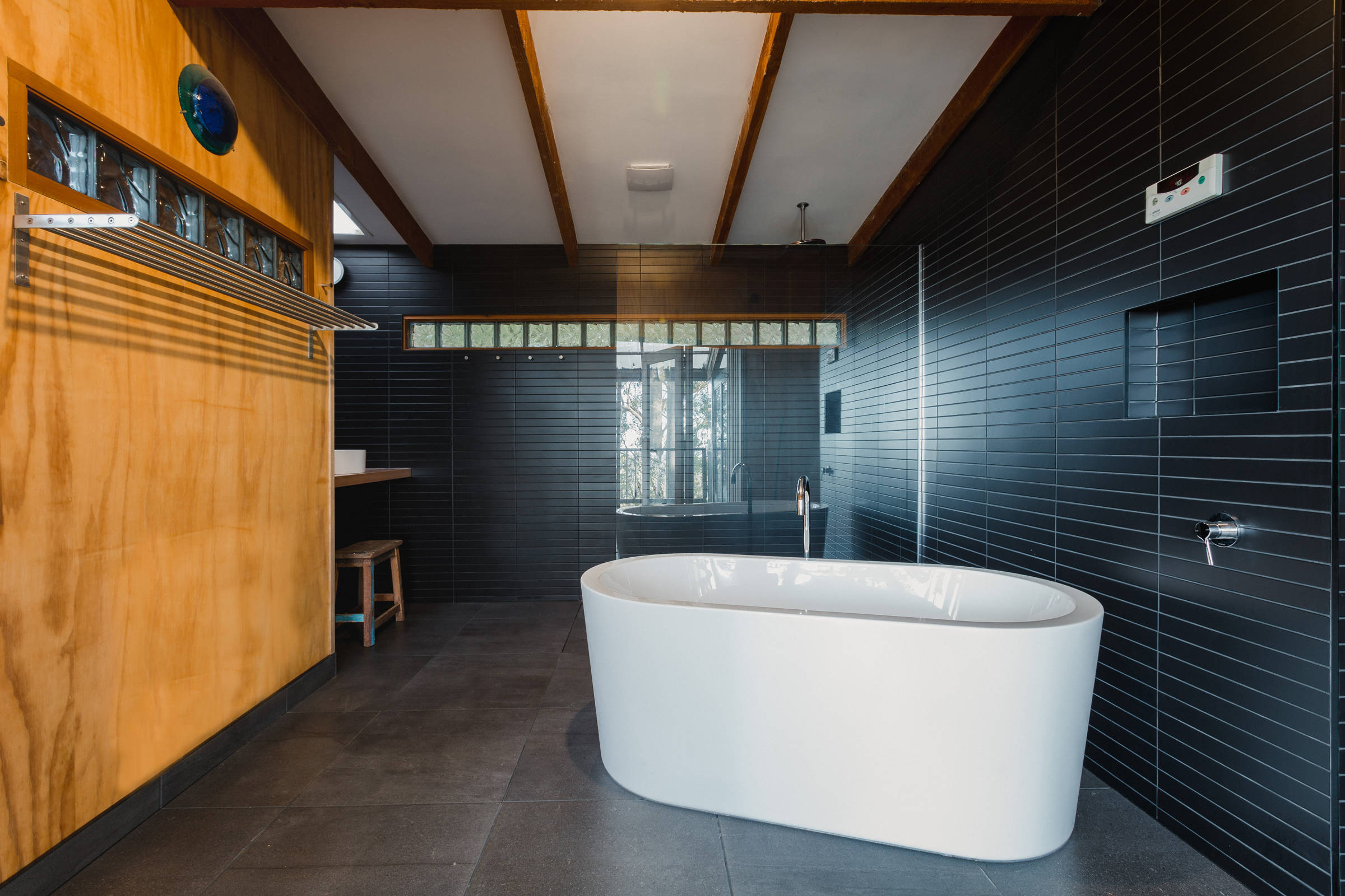 Custom Japanese inspired bathroom renovation features a freestanding bath, black mosaic tiles, laid with the utmost accuracy. This architectural bathroom renovation was designed to give a contemporary feel with increased natural light from a new skylight. Photo: Jordan Davis.